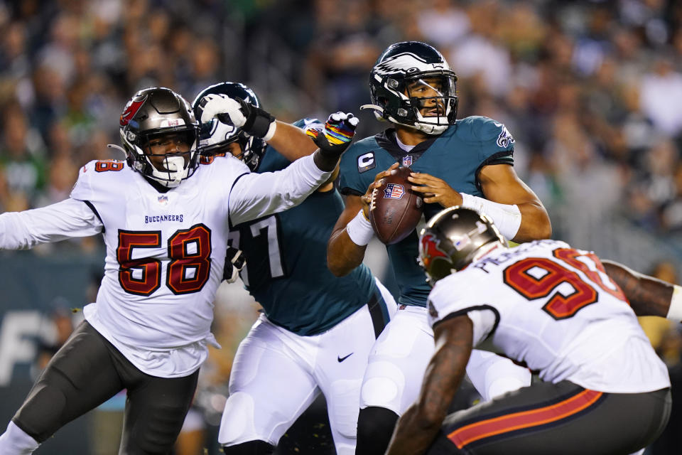 Philadelphia Eagles quarterback Jalen Hurts (1) looks to pass under pressure from Tampa Bay Buccaneers outside linebacker Shaquil Barrett (58) during the first half of an NFL football game Thursday, Oct. 14, 2021, in Philadelphia. (AP Photo/Matt Rourke)