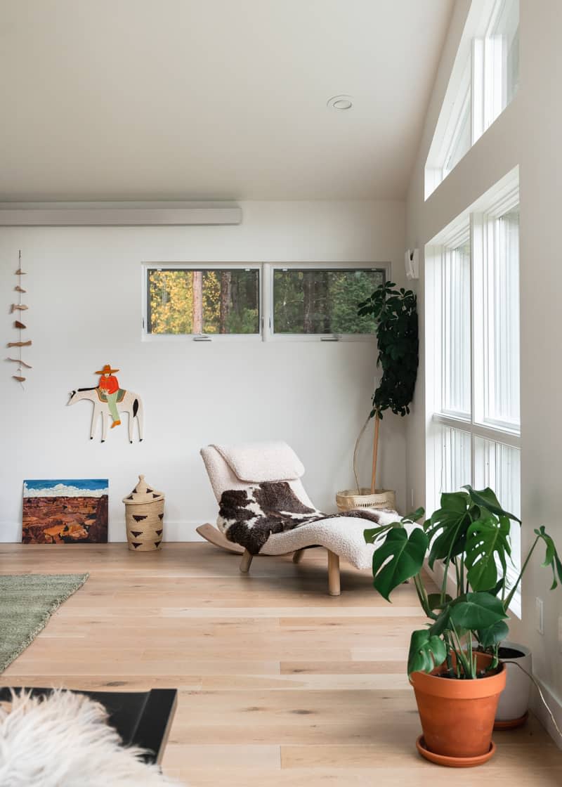 Cow hide draped over chaise lounge in light filled living room.