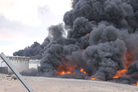 Smoke rises from burning oil storage tanks at the port of Ras Lanuf, Libya January 22, 2016. REUTERS/Stringer