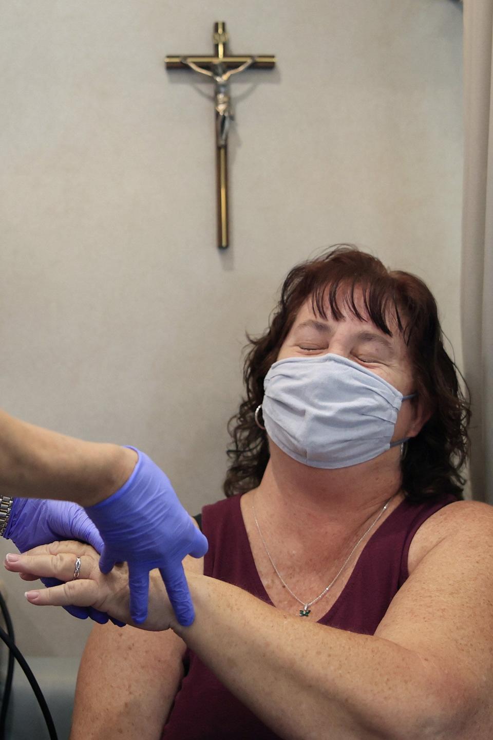 Victoria Nelson steels herself for a blood sample prick during a checkup inside an Ascension St. Vincent's mobile health care clinic. The five-unit fleet serves the uninsured, underinsured and low-income people in Duval, Clay, Nassau, Putnam and St. Johns counties.