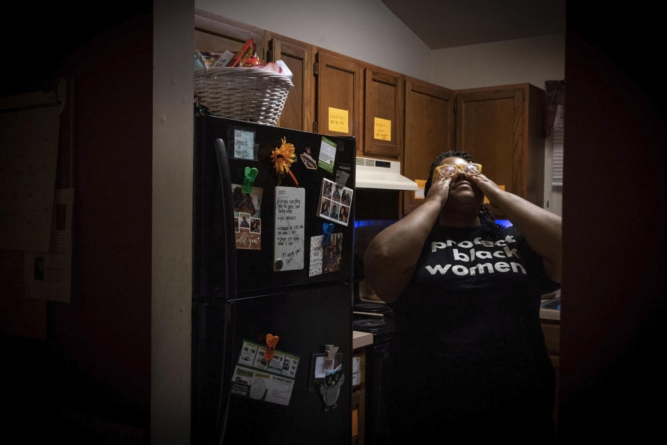 Jessica Guthrie rubs her eyes as she takes a deep breath at night after a full day of caregiving in Fredericksburg, Va., on Monday, Sept. 19, 2022. Some days she mourns the life that could have been and everything she has had to sacrifice. She sees undeniable parallels between all that her mother sacrificed and what she now has given up. But she wouldn’t change a thing. Her exhausting experience as a caregiver has added purpose to her life. She feels she is also helping other Black caregivers to be seen and heard. (AP Photo/Wong Maye-E)