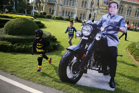 A boy in a Batman costume runs next to a cardboard cutout of Thailand's Prime Minister Prayuth Chan-ocha during preparations for national Children's Day at the Government House in Bangkok, Thailand, January 12, 2018. REUTERS/Athit Perawongmetha