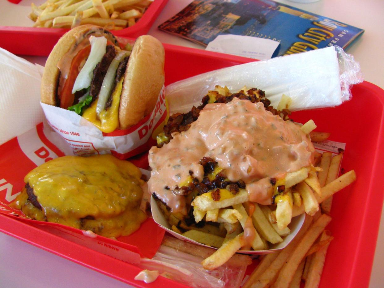 In-N-Out burger and fries on a red tray inside of the restaurant.