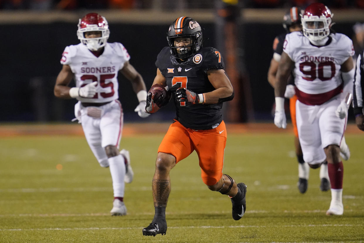 Oklahoma State running back Jaylen Warren (7) carries during an NCAA college football game against Oklahoma, Saturday, Nov. 27, 2021, in Stillwater, Okla. (AP Photo/Sue Ogrocki)