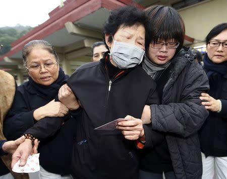 Family members of a passenger who died in the TransAsia Airways plane crash cry at a funeral parlour in Taipei February 5, 2015. REUTERS/Stringer