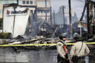 Policías del condado San Diego montan guardia el domingo 31 de mayo de 2020 frente a una sucursal bancaria quemada en La Mesa, California, después de una protesta por la muerte de George Floyd en Minneapolis. (AP Foto/Gregory Bull)