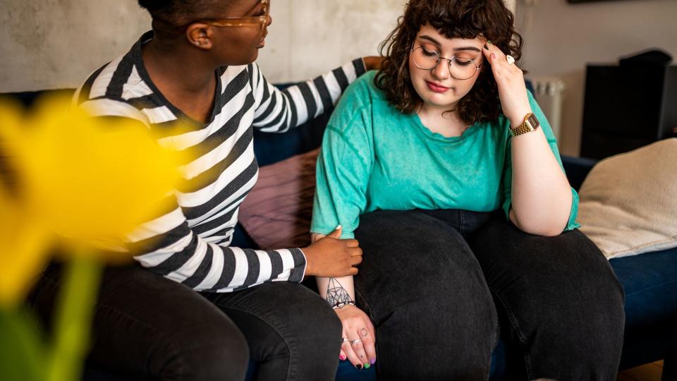 Two women are sitting in the living room talking