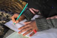 Internally displaced girl, Alaa Hussein Hadaja,10, studies inside her tent in Atmeh camp