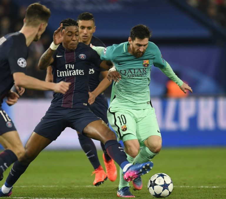 Paris Saint-Germain's Presnel Kimpembe (left) vies with Barcelona's Lionel Messi during the Champions League match at the Parc des Princes stadium in Paris, on February 14, 2017