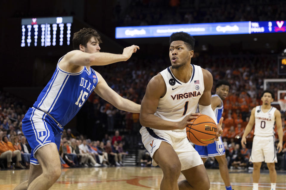 Virginia's Jayden Gardner (1) is defended by Duke's Ryan Young (15) during the second half of an NCAA college basketball game in Charlottesville, Va., Saturday, Feb. 11, 2023. (AP Photo/Mike Kropf)