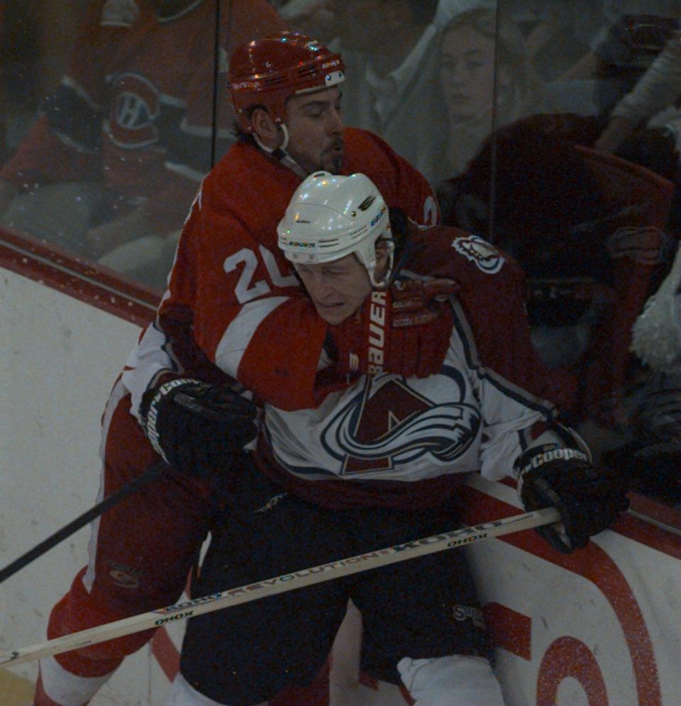 Colorado Avalanche's Alexei Gusarov is checked into the boards during the second period by Detroit Red Wings' Martin Lapointe in Game 5 of the Western Conference finals at McNichols Sports Arena in Denver, May 24, 1997.