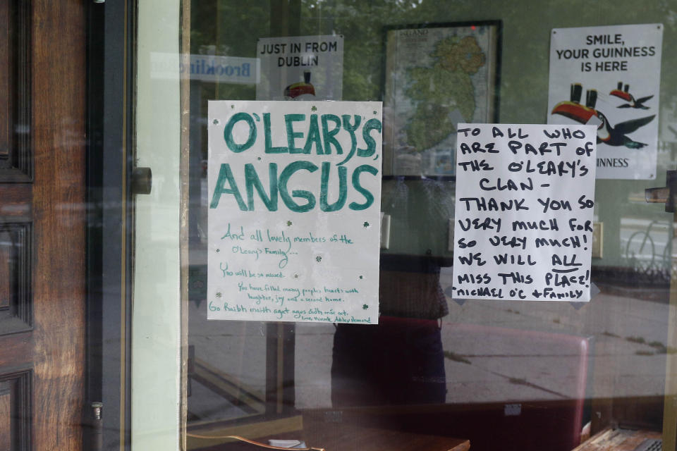 A sign by the owners is posted on a window at the O'Leary's Irish Pub, Tuesday, Aug. 4, 2020, in Brookline, Mass. After being in business for nearly three decades, the pub permanently closed during the coronavirus pandemic. (AP Photo/Bill Sikes)