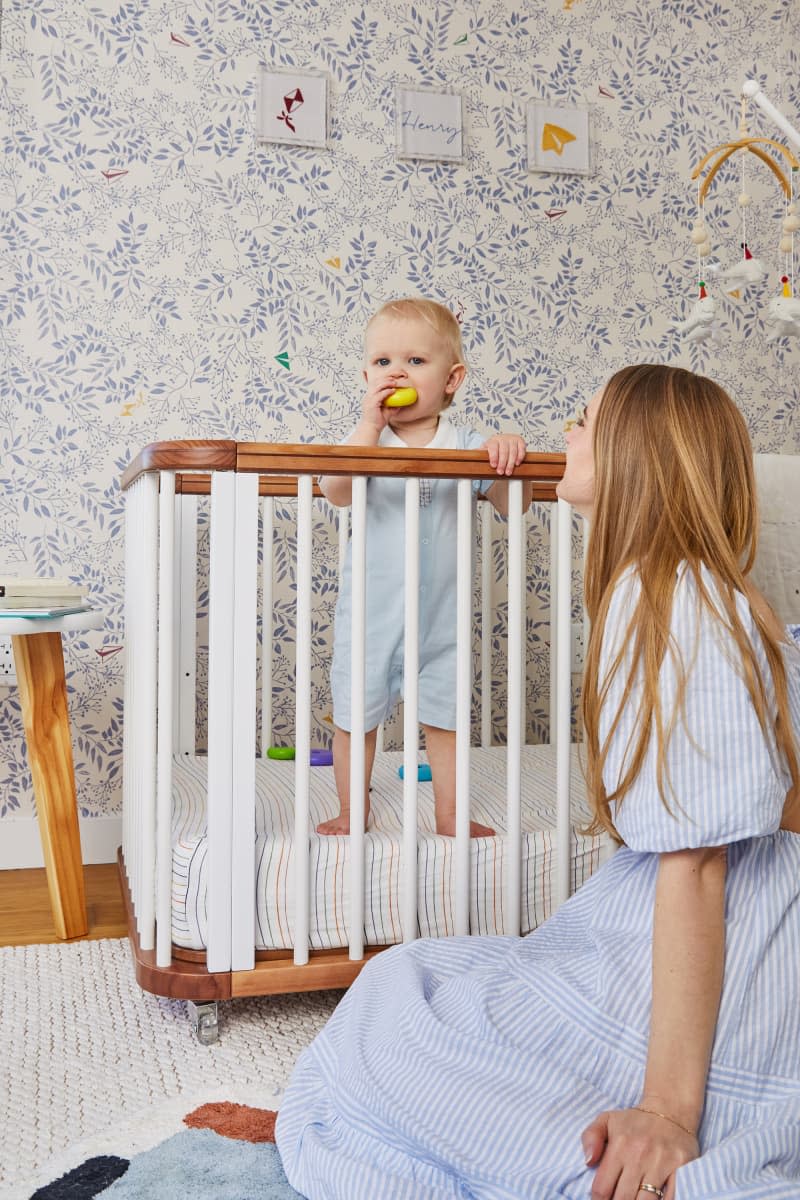 Baby standing in crib.