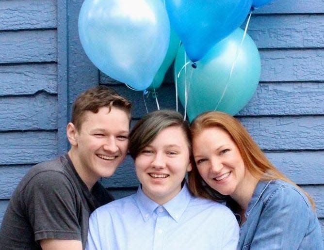 Lucas, Adrian and mom Heather Green of Kentucky embrace at Adrian's transgender coming out photo shoot. After Adrian came out in September 2018 at age 19, Heather celebrated his 20th birthday with a baby-gender-reveal-themed photo shoot.