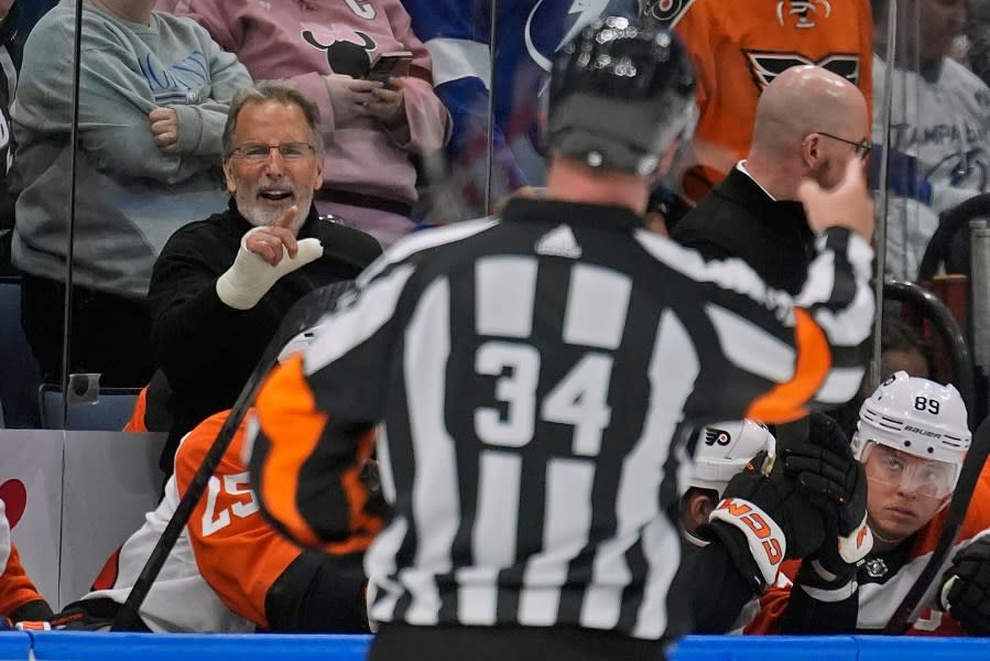 Philadelphia Flyers head coach John Tortorella, left, yells at referee Brad Meier (34) after being kicked out the game against the Tampa Bay Lightning during the first period of an NHL hockey game Saturday, March 9, 2024, in Tampa, Fla. (AP Photo/Chris O’Meara)