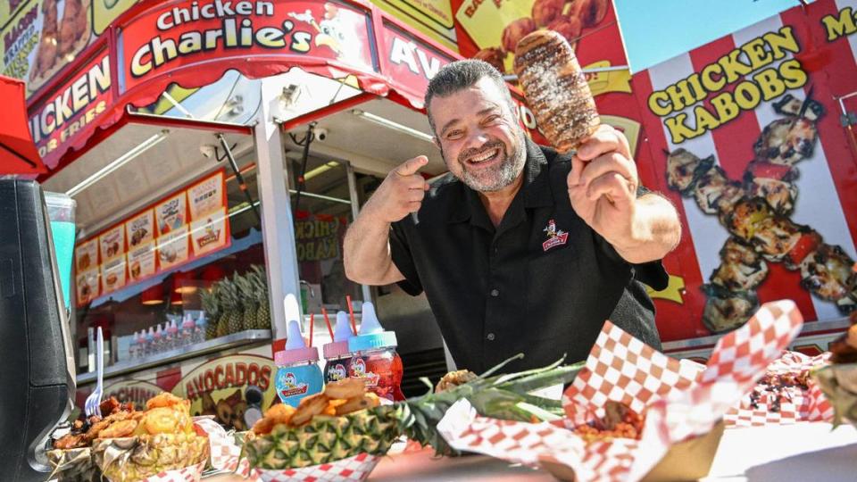 Chicken Charlie, AKA Charlie Boghosian of Chicken Charlie’s, holds up one of his new concoctions - a deep-fried s’more on a stick - at his usual spot at this year’s Big Fresno Fair.