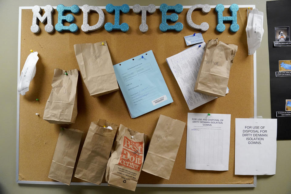 Paper bags containing N95 masks hang on a bulletin board waiting to be used again by staff inside a portion of Scotland County Hospital where COVID-19 patients have been isolated Tuesday, Nov. 24, 2020, in Memphis, Mo. The rural hospital is facing staffing shortages so severe that the hospital put out an appeal for anyone with health care experience, including retirees, to come to work. (AP Photo/Jeff Roberson)