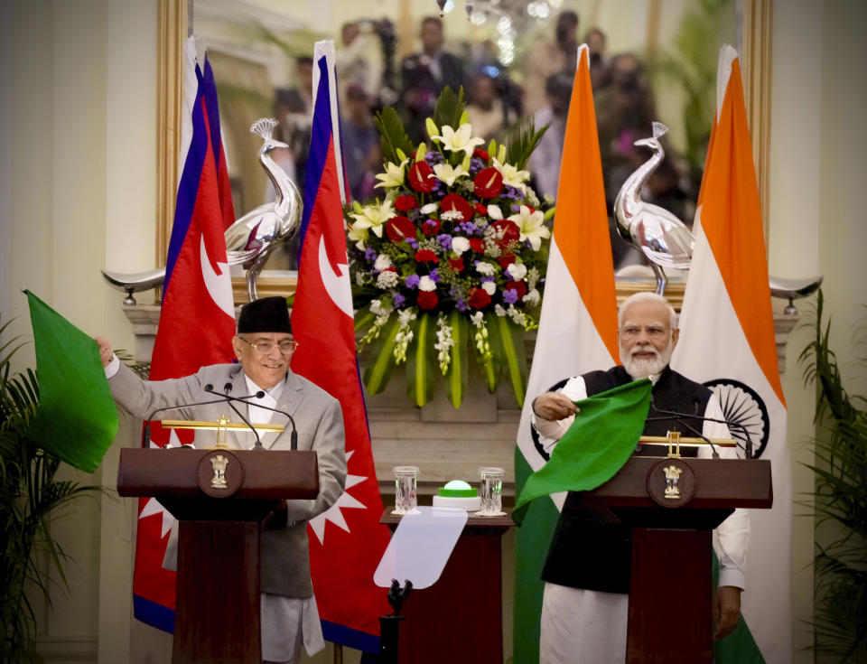 Nepal’s Prime Minister Pushpa Kamal Dahal and his Indian counterpart Narendra Modi, right, jointly flag off a cargo train from India to Nepal after their meeting in New Delhi, India, Thursday, June 1, 2023. Dahal arrived Wednesday on a state visit, his first trip abroad since taking power in December last year. (AP Photo/Manish Swarup)