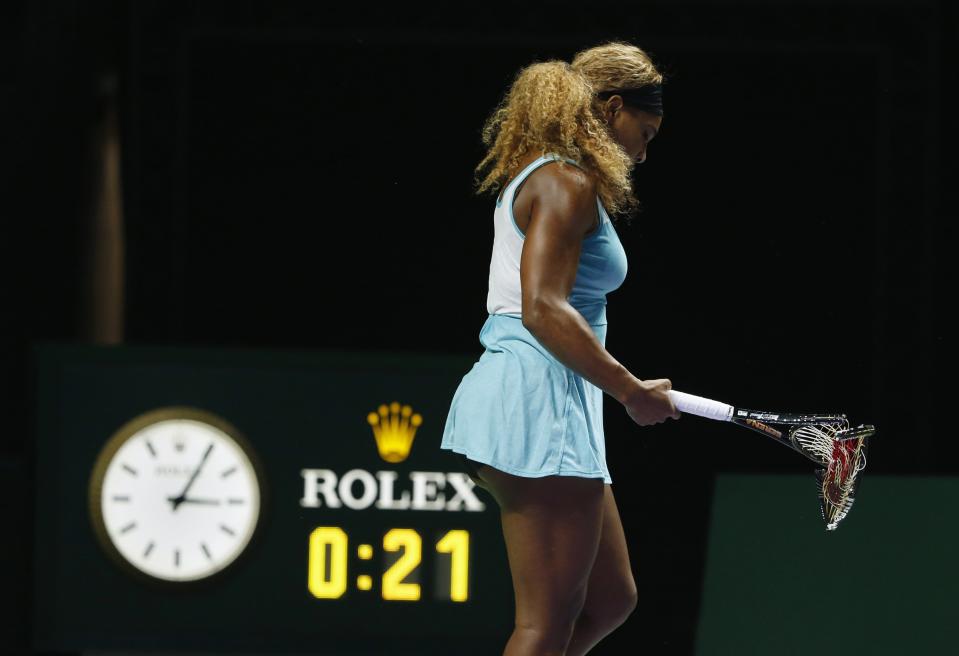 Serena Williams of the U.S. walks off the court with her second broken racquet during her WTA Finals singles semi-finals tennis match against Caroline Wozniacki of Denmark, at the Singapore Indoor Stadium