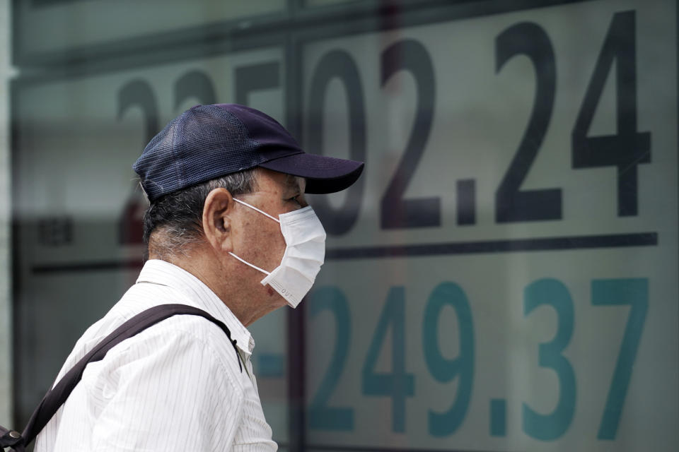 A man looks at an electronic stock board showing Japan's Nikkei 225 index at a securities firm in Tokyo Monday, July 27, 2020. Asian stock markets were mixed Monday amid U.S.-China tension and concern a recovery from the coronavirus pandemic might be weakening. (AP Photo/Eugene Hoshiko)