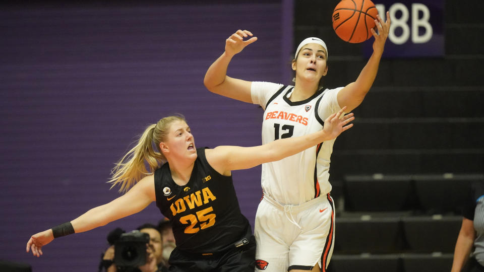 Iowa forward Monika Czinano (25) defends against Oregon State forward Jelena Mitrovic (12) during the first half of an NCAA college basketball game in the Phil Knight Legacy tournament Friday, Nov. 25, 2022, in Portland, Ore. (AP Photo/Rick Bowmer)