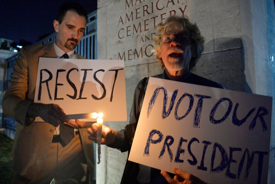 <p>Tim Ortiz y Donald Goertzen protestan contra Donald Trump en la puerta del cementerio estadounidense de Manila, Filipinas. REUTERS/Ezra Acayan </p>