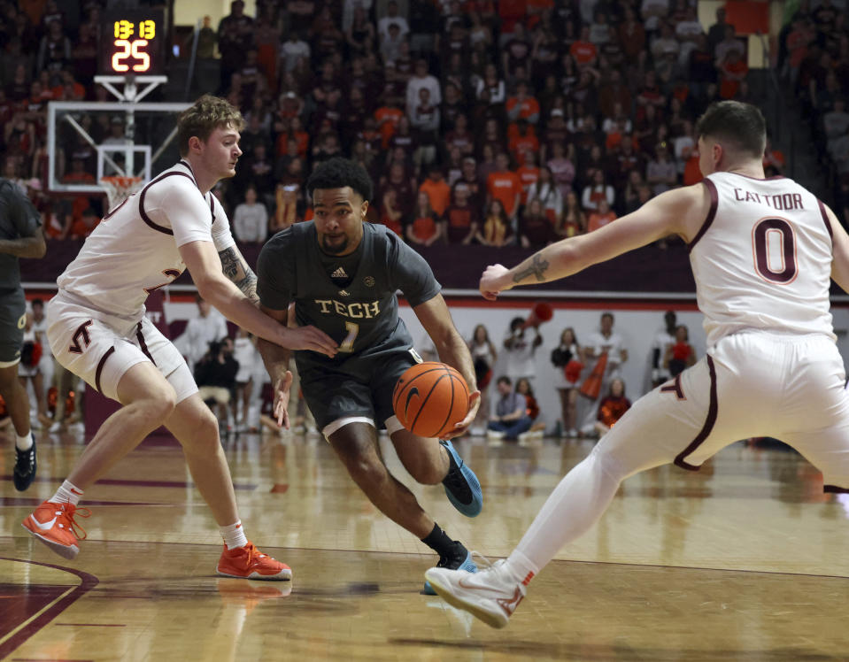 Georgia Tech's Kyle Sturdivant (1) drives while defended by Virginia Tech's Tyler Nickel (23) and Hunter Cattoor (0) in the first half of an NCAA college basketball game, Saturday, Jan. 27, 2024, in Blacksburg, Va. (Matt Gentry/The Roanoke Times via AP)