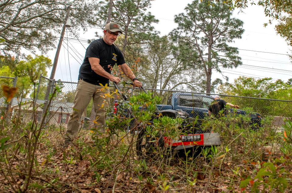 Milton Commissioner Kerry Smith clears brush during the Santa Rosa County Poor Farm Cemetery clean up in Milton Saturday, March 23, 2024. The Santa Rosa County Poor Farm was established in 1890 to house and care for people who were unable to care for themselves and didn't have family members to care for them.