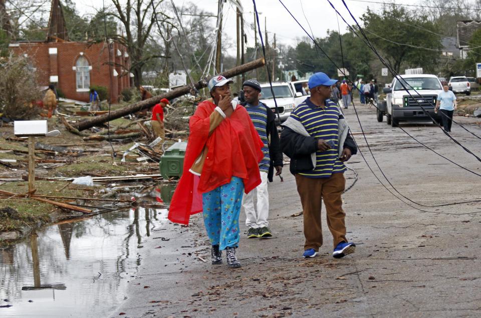 Residents of south Hattiesburg, Miss., survey the damage to their community following a early morning tornado blew through, Saturday, Jan. 21, 2017. The tornado was part of a wall of stormy weather traveling across the region, bringing with it rain and unstable conditions. (AP Photo/Rogelio V. Solis)