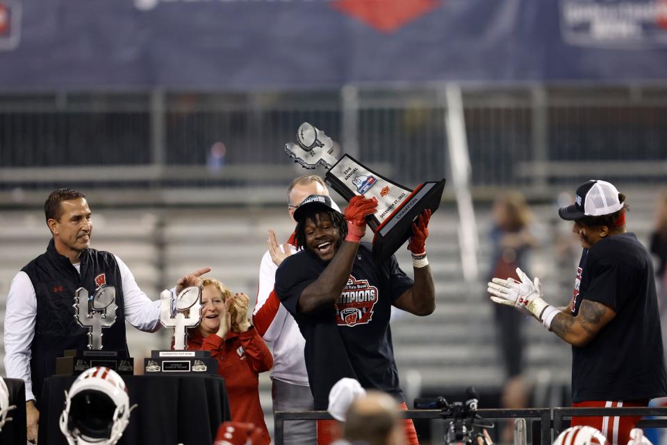 Linebacker Jordan Turner hoists the Guaranteed Rate Bowl trophy after Wisconsin's victory over Oklahoma State.