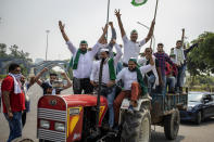 Indian farmers shout slogans as they ride tractors towards New Delhi in Noida, India, Friday, Sept. 25, 2020. (AP Photo/Altaf Qadri)