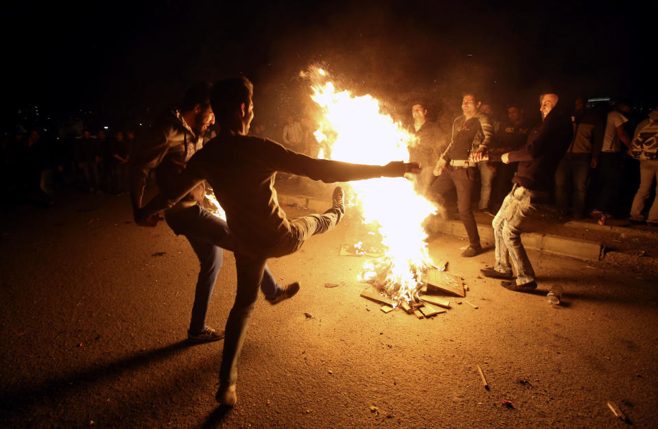 In this picture taken on Tuesday, March 18, 2014, Iranians dance around a bonfire during a celebration, known as “Chaharshanbe Souri,” or Wednesday Feast, marking the eve of the last Wednesday of the solar Persian year, in Pardisan park, Tehran, Iran. The festival has been frowned upon by hard-liners since the 1979 Islamic revolution because they consider it a symbol of Zoroastrianism, one of Iran’s ancient religions of Iranians. They say it goes against Islamic traditions. (AP Photo/Vahid Salemi)