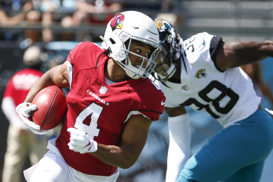 Arizona Cardinals wide receiver Rondale Moore (4) looks for extra room to run as he gets past Jacksonville Jaguars safety Andre Cisco (38) during the first half of an NFL football game, Sunday, Sept. 26, 2021, in Jacksonville, Fla. (AP Photo/Stephen B. Morton)
