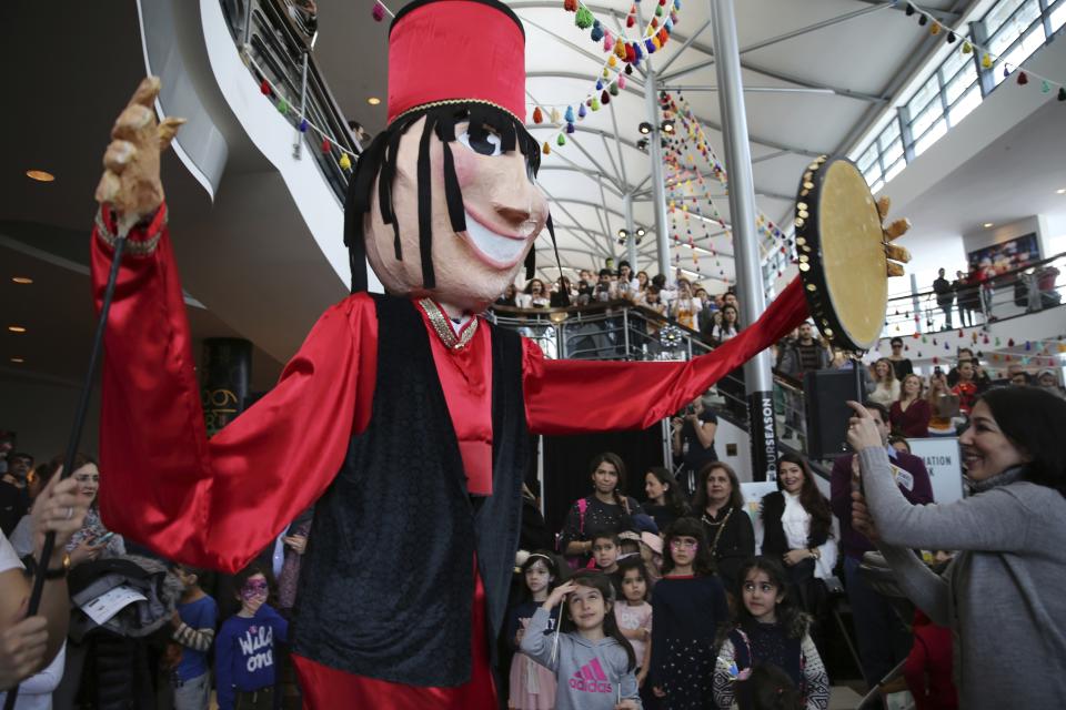 In this Saturday, March 9, 2019, Sara Ahmadieh, inside the Haji Firooz mascot, performs during the Tirgan Nowruz Festival in Toronto, Canada. Sara, 29, has migrated from Tehran, Iran more about 7 years ago, she has graduated from Theatre Production in Toronto and working at the moment. The event aims to preserve and celebrate Iranian and Persian culture, said festival CEO Mehrdad Ariannejad. Among those who attended were second-and third-generation immigrants, many of whom have never been to Iran or have not been there since leaving the country following the 1979 Islamic Revolution. (AP Photo/Kamran Jebreili)