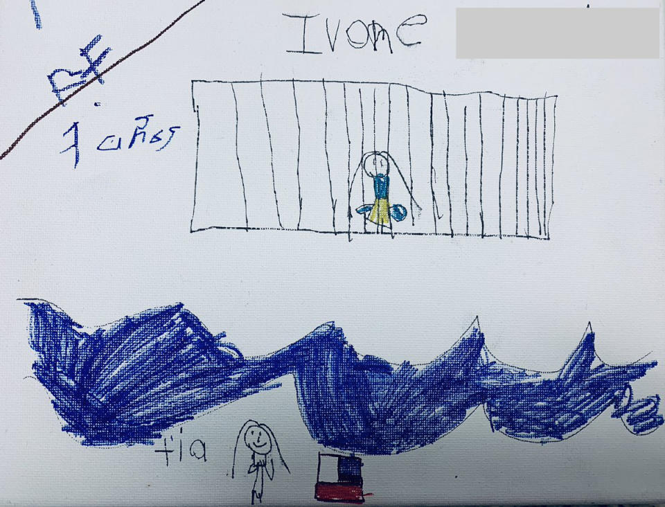 Ivone, 7, draws herself in a cage while her tía watches across the Rio Grande river next to an American flag. | Courtesy of Belinda Arriaga