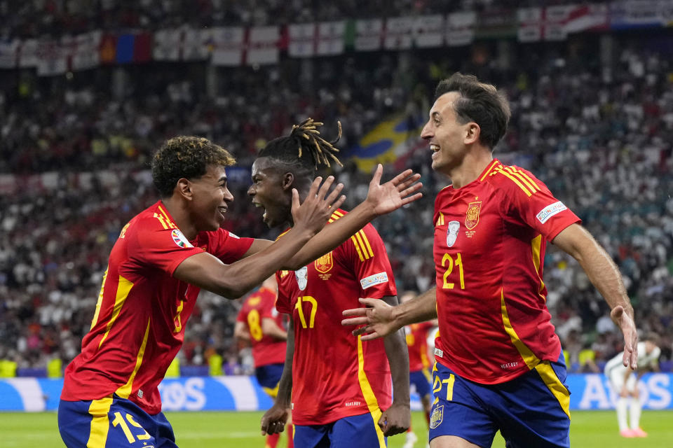 Spain's Mikel Oyarzabal, right, celebrates with Nico Williams and Lamine Yamal, left, after scoring his side's second goal during the final match between Spain and England at the Euro 2024 soccer tournament in Berlin, Germany, Sunday, July 14, 2024. (AP Photo/Manu Fernandez)