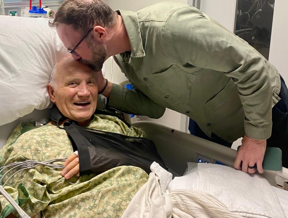 Casey Wolters kisses his father, Bill, at North Austin Medical Center on Wednesday. The 80-year-old had an AED surgically implanted in his chest after collapsing on his way out of a football game.