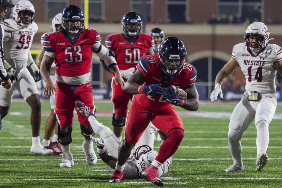 Liberty's Quinton Cooley runs by New Mexico's State Dylan Early, center, and Sone Aupiu, right, during the first half of the Conference USA championship NCAA college football game, Friday, Dec. 1, 2023, in Lynchburg, Va. (AP Photo/Robert Simmons)