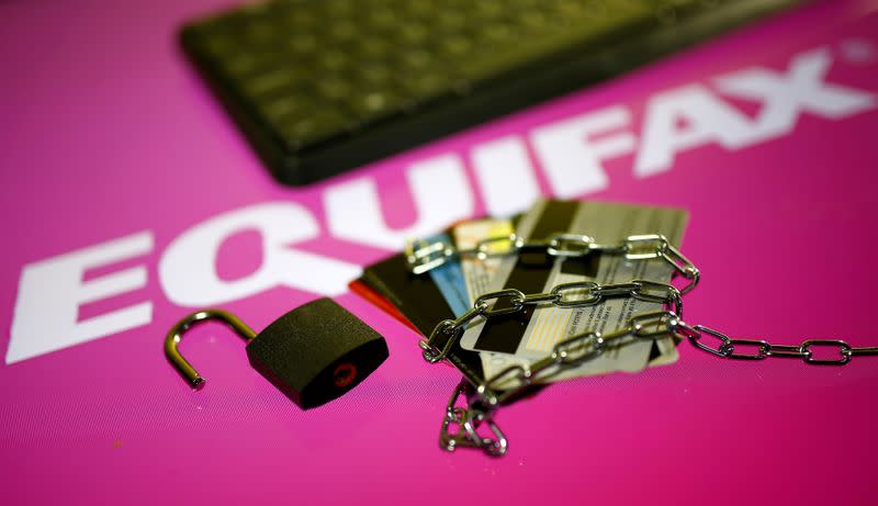 FILE PHOTO: Credit cards, a chain and an open padlock is seen in front of displayed Equifax logo in this illustration