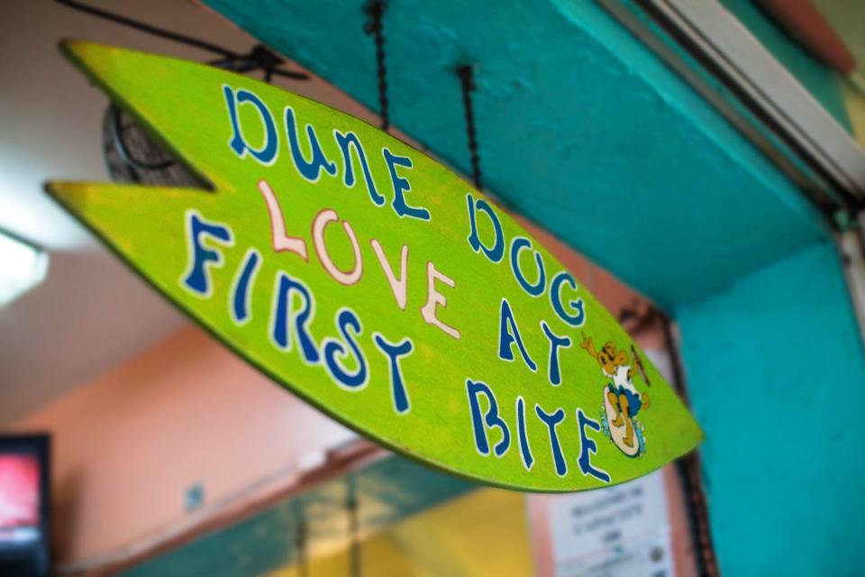 A sign hangs from a doorpost at the Dune Dog Cafe restaurant in Jupiter.