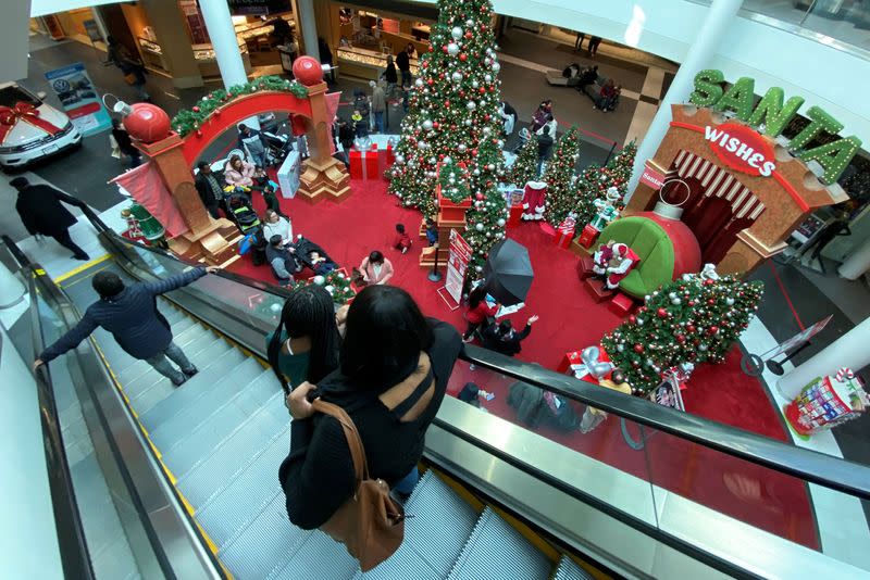 Families wait in line to meet Santa Claus at Fashion Centre at Pentagon City, decorated for the holidays, in Arlington, Virginia