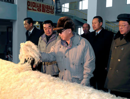 FILE PHOTO: North Korean leader Kim Jong-il (C) visits the February 8 Vinalon Complex in Hamheung, northeast of Pyongyang in this photo released by North Korea's KCNA news agency February 10, 2010. The Korean characters read: "Improvement of people's lives". REUTERS/KCNA/File Photo