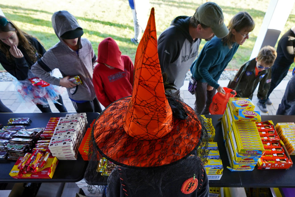 Parents and children receive free Halloween candy, Tuesday, Oct. 31, 2023, in Lewiston, Maine. Locals seek a return to normalcy after a shooting that claimed multiple lives in their community on Oct. 25. The deadliest shooting in Maine's history stunned a state of 1.3 million people that has relatively little violent crime. (AP Photo/Matt York)