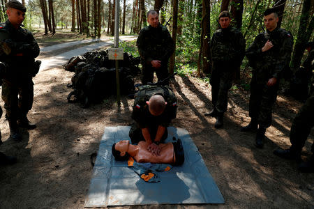 Territorial soldiers practise first aid during their training for Poland's Territorial Defence Forces, near a shooting range near Siedlce, Poland, April 21, 2018. REUTERS/Kacper Pempel/Files