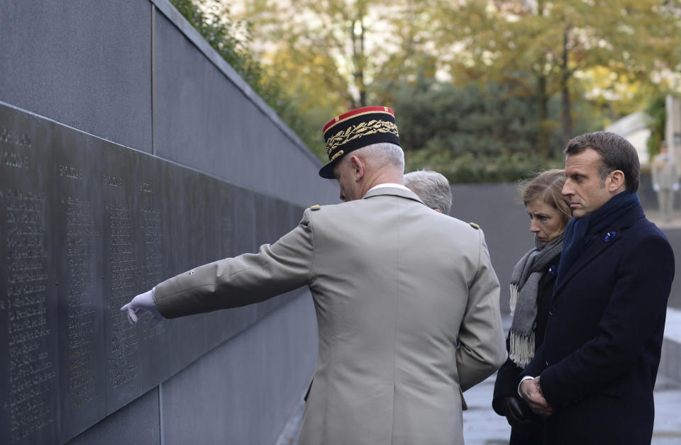 French President Emmanuel Macron listens to explanations from French army Chief of Staff Gen. Francois Lecointre as he inaugurates a memorial for soldiers fallen in foreign conflicts, Monday Nov. 11, 2019 in Paris. As part of commemorations marking 101 years since World War I's Armistice, French President Emmanuel Macron led a ceremony for the 549 French soldiers who died in 17 theaters of conflict since the 60s. (Johanna Geron/Pool via AP)