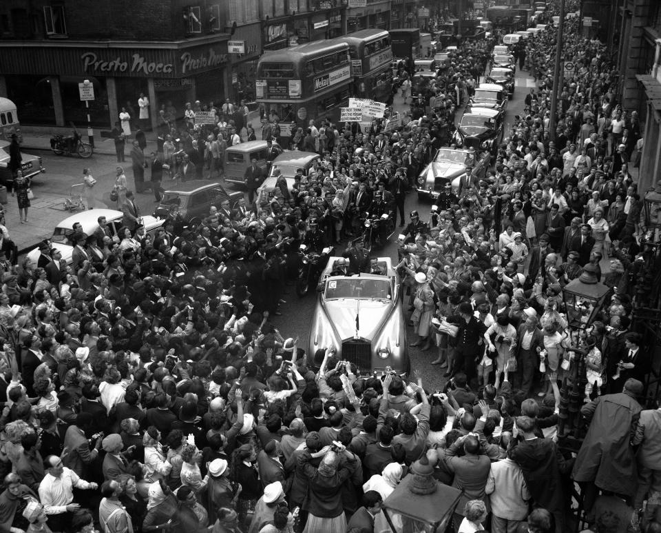 FILE - In this Tuesday, July 11, 1961 file photo, Russian cosmonaut Major Yuri Gagarin, standing in an open car, waves to crowds of spectators as he drives into London from the London airport. The successful one-orbit flight on April 12, 1961 made the 27-year-old Gagarin a national hero and cemented Soviet supremacy in space until the United States put a man on the moon more than eight years later. (AP Photo/File)