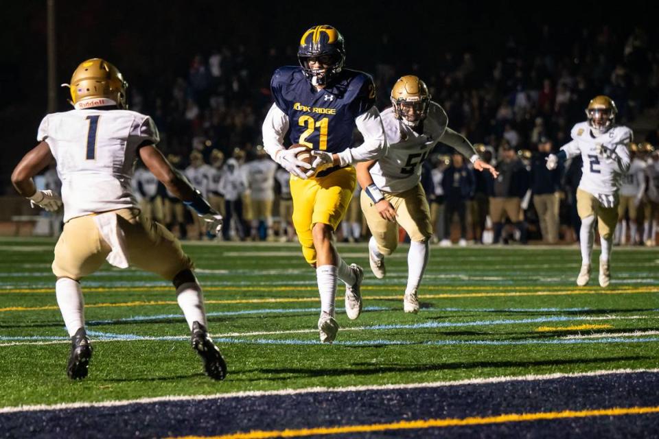 Oak Ridge Trojan tight end Kaleb Edwards (21) gets near the end zone on a reception as Elk Grove’s Wayshawn Parker (1) defends at left during the second quarter of the high school football CIF Sac-Joaquin Section playoff game Friday, Nov. 11, 2022, at Oak Ridge High School in El Dorado Hills.