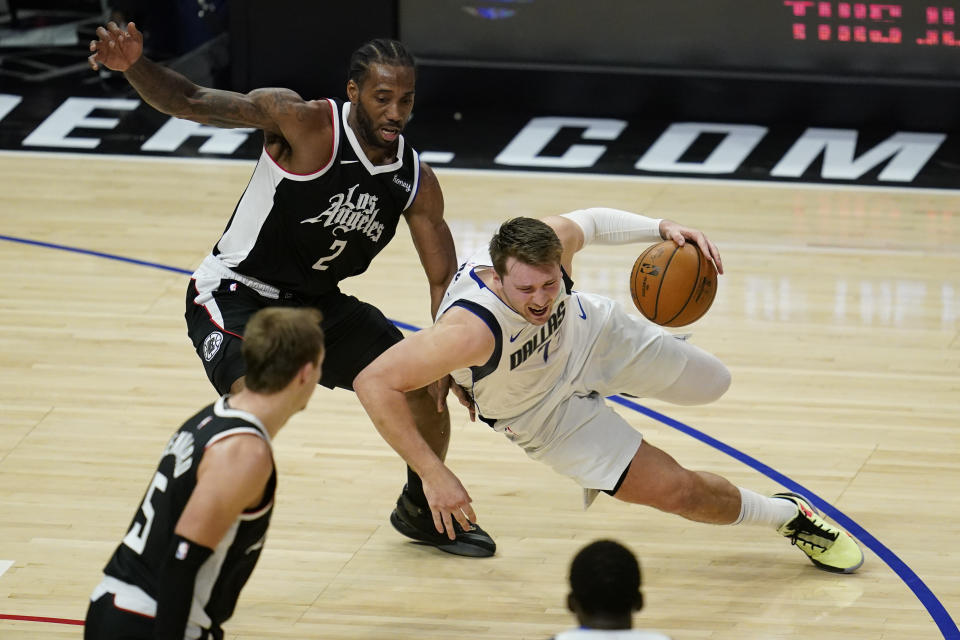 Los Angeles Clippers forward Kawhi Leonard (2) defends against Dallas Mavericks guard Luka Doncic (77) during the fourth quarter of Game 7 of an NBA basketball first-round playoff series Sunday, June 6, 2021, in Los Angeles, Calif. (AP Photo/Ashley Landis)