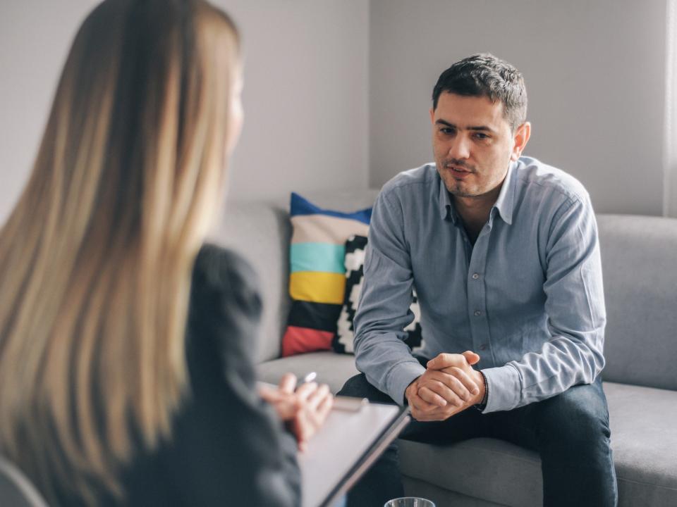 A stock photo of a man speaking to a counselor.
