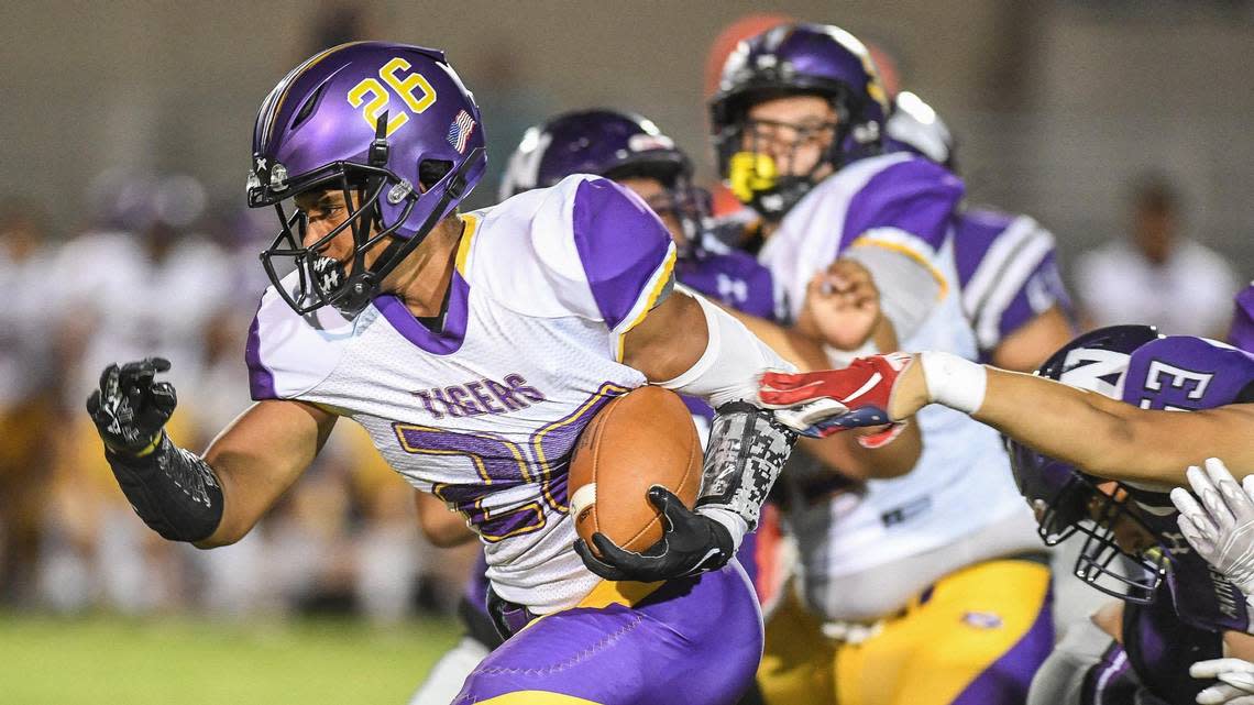 Lemoore’s Anthony Garcia busts through the line for a gain against Washington Union in their game at Washington Union on Friday, Aug. 26, 2022. The Tigers host Clovis West on Friday, Sept. 2, 2022.